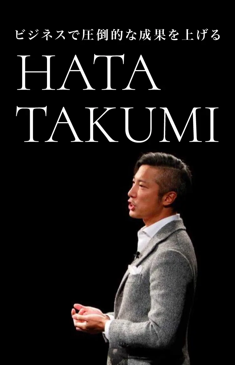 黒い舞台の上で聴衆に語りかける、グレーのジャケット姿の秦卓民